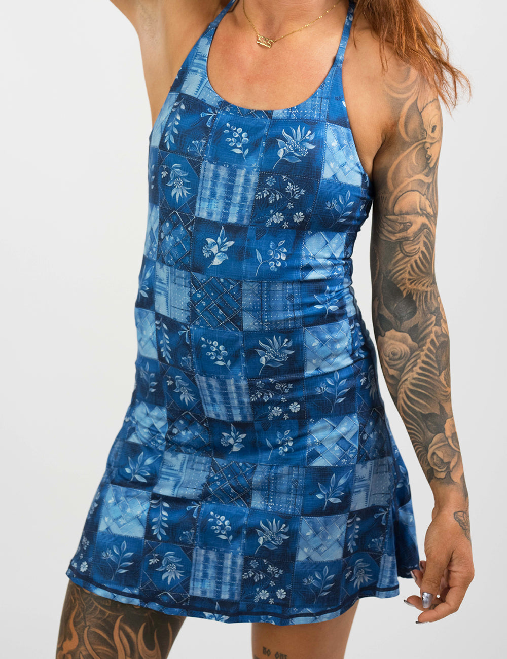 front of the shorter length blue patchwork flowers dress against a white background