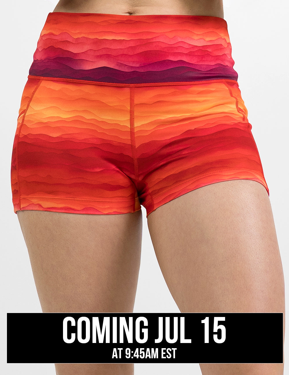 front of the red, yellow, and orange sunset stripes pattern 2.5 inch shorts against a white background, coming july 15th