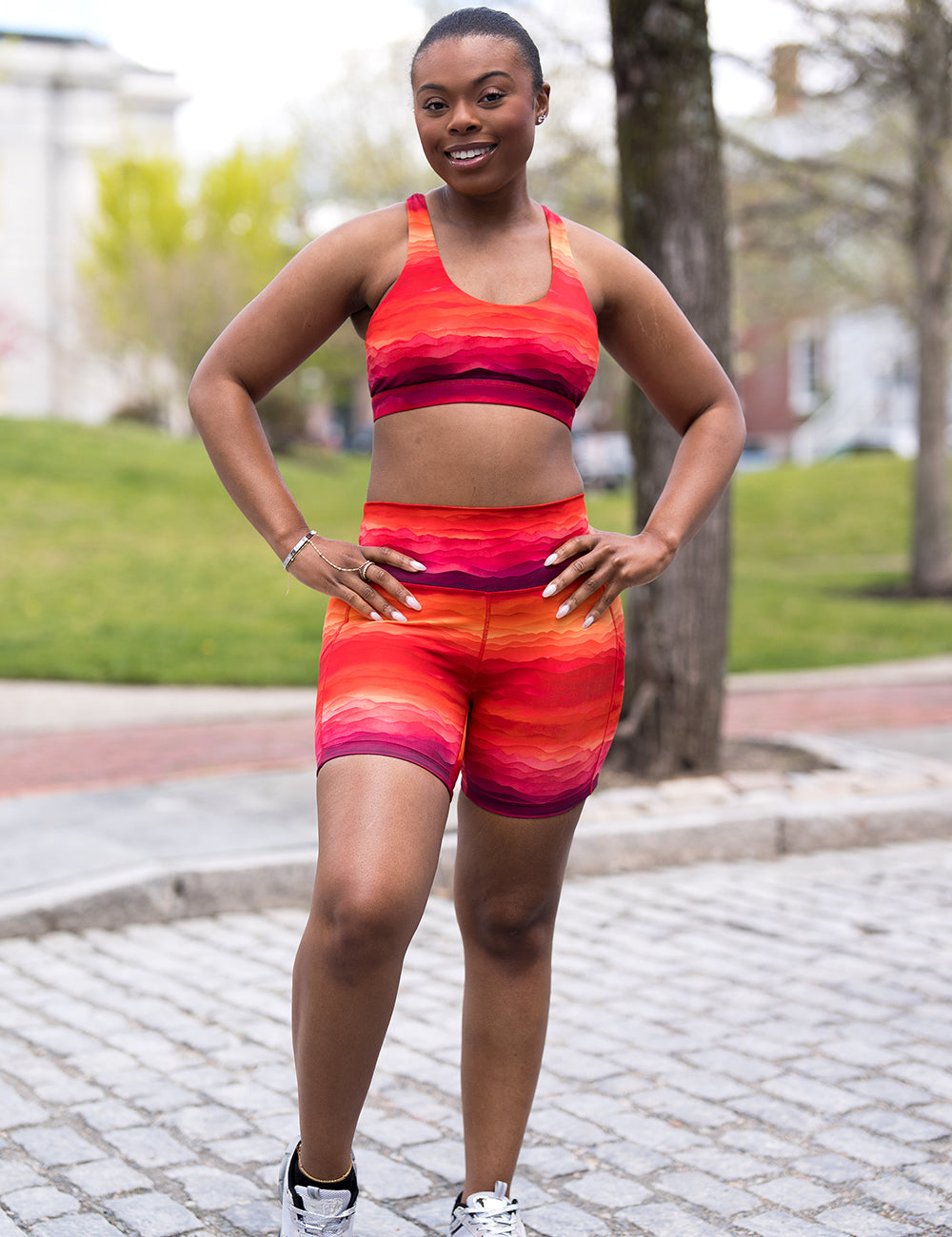 model wearing the orange, yellow, and red stripes sunset 7 inch shorts