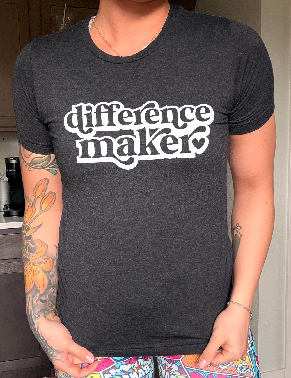 black unisex tee with the words "difference maker" followed by a single heart on it