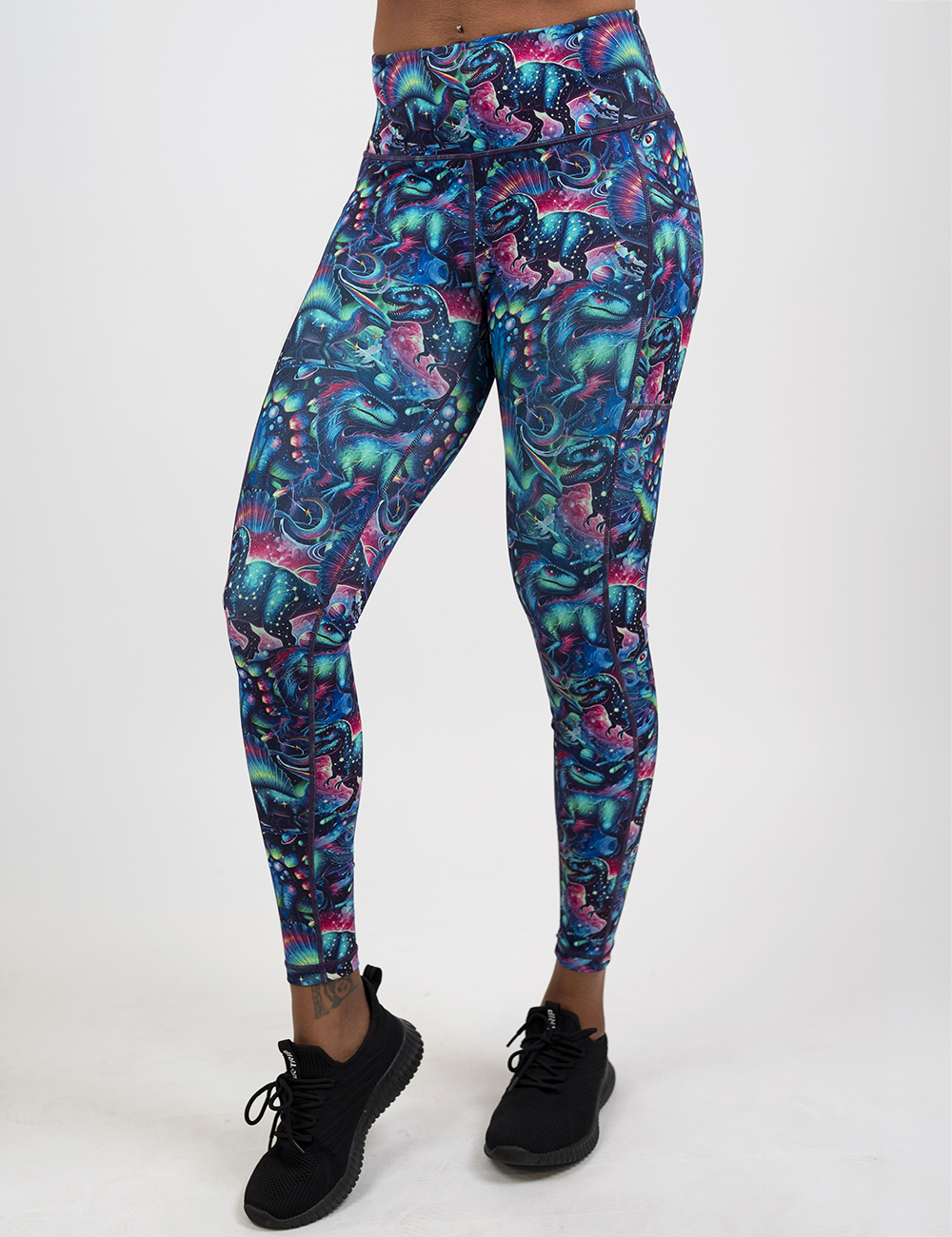 model wearing the full length colorful dinosaur leggings against a white background