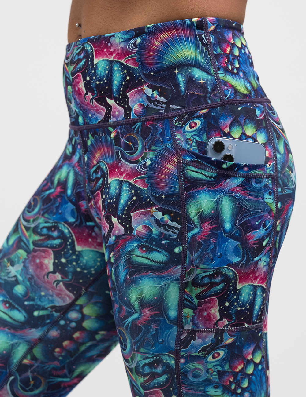 close up of the colorful dinosaur leggings with a phone in the pocket
