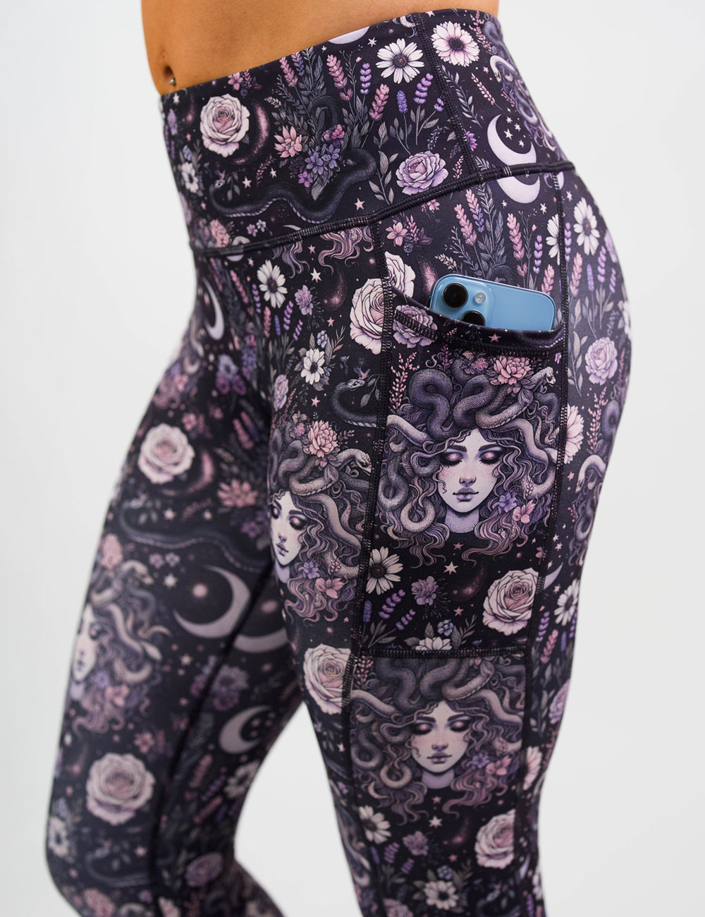 close up of the purple medusa with flowers leggings with a phone in its pocket