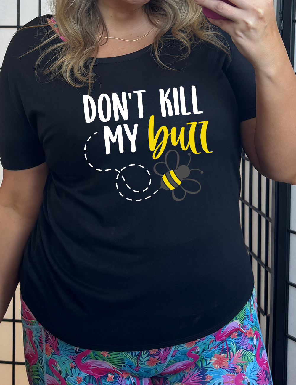black unisex tee with the graphic of a boho circled design filled with flowers of varied size, some branches, some stars, and in the center a fancy bee