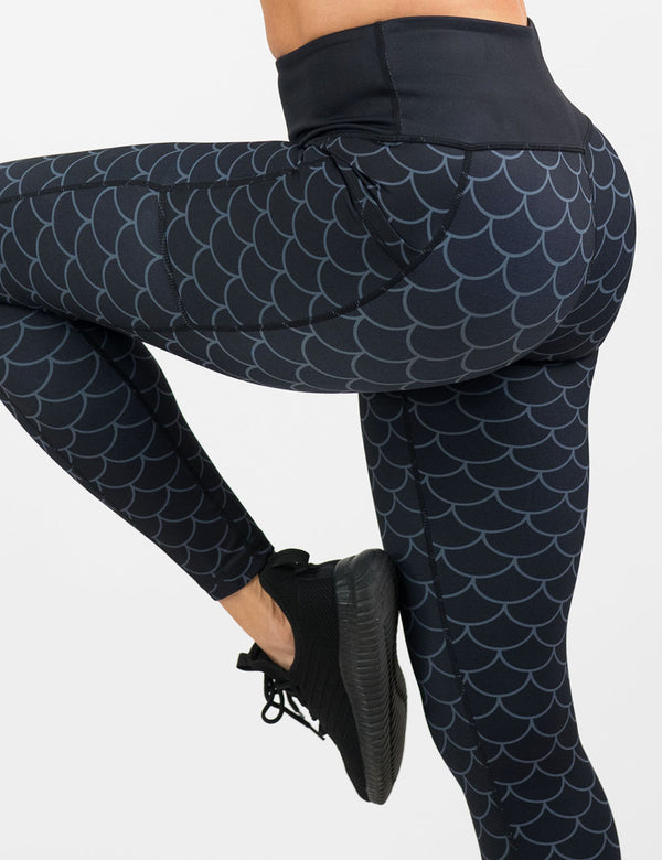  dragon scale outline against a dark background pattern full length leggings facing the side against a white background