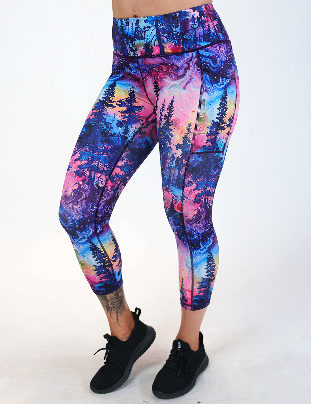 the watercolor rainbow patterned forest capri leggings against a white background