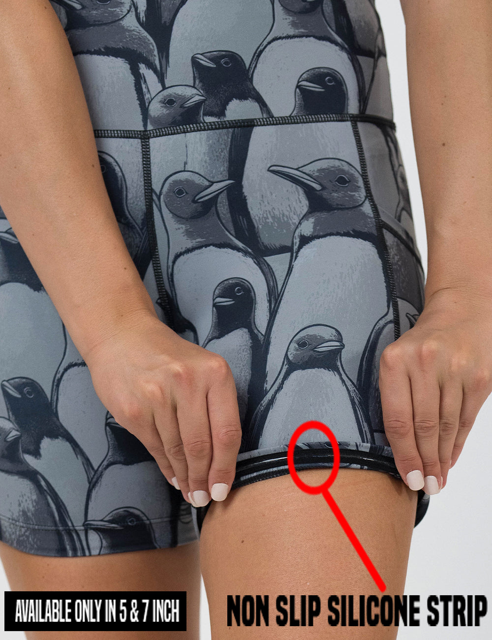 close up of the penguin patterned shorts being rolled up to show the non slip silicone strip found in the lining of the 5 and 7 inch shorts