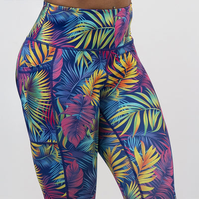 front of the vibrant rainforest leaves leggings against a white background