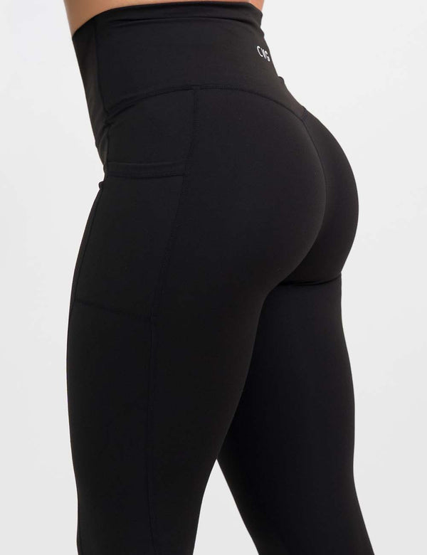 back of the all black essential style leggings against a white background