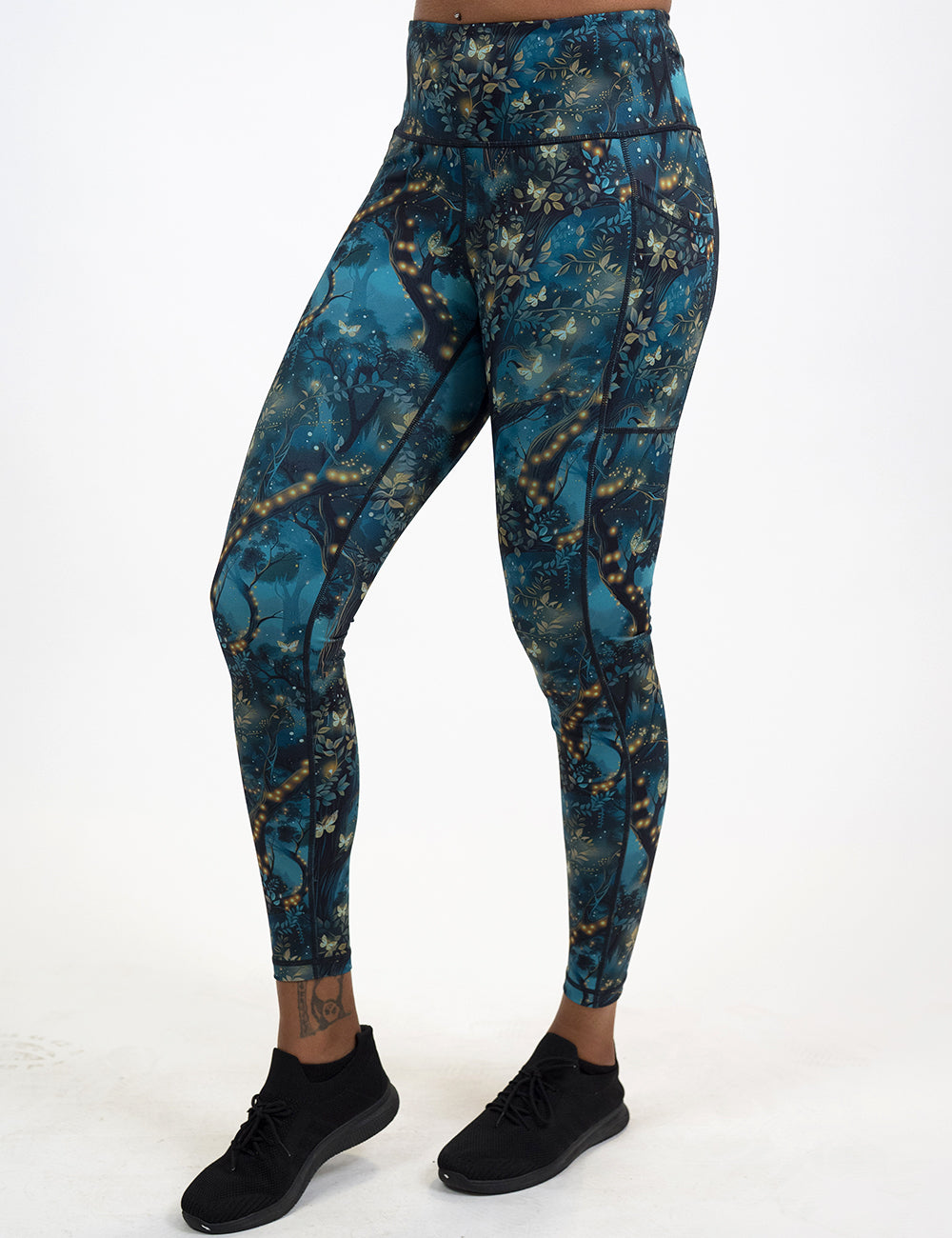 model wearing the full length forest filled with firefly's pattern leggings against a white background
