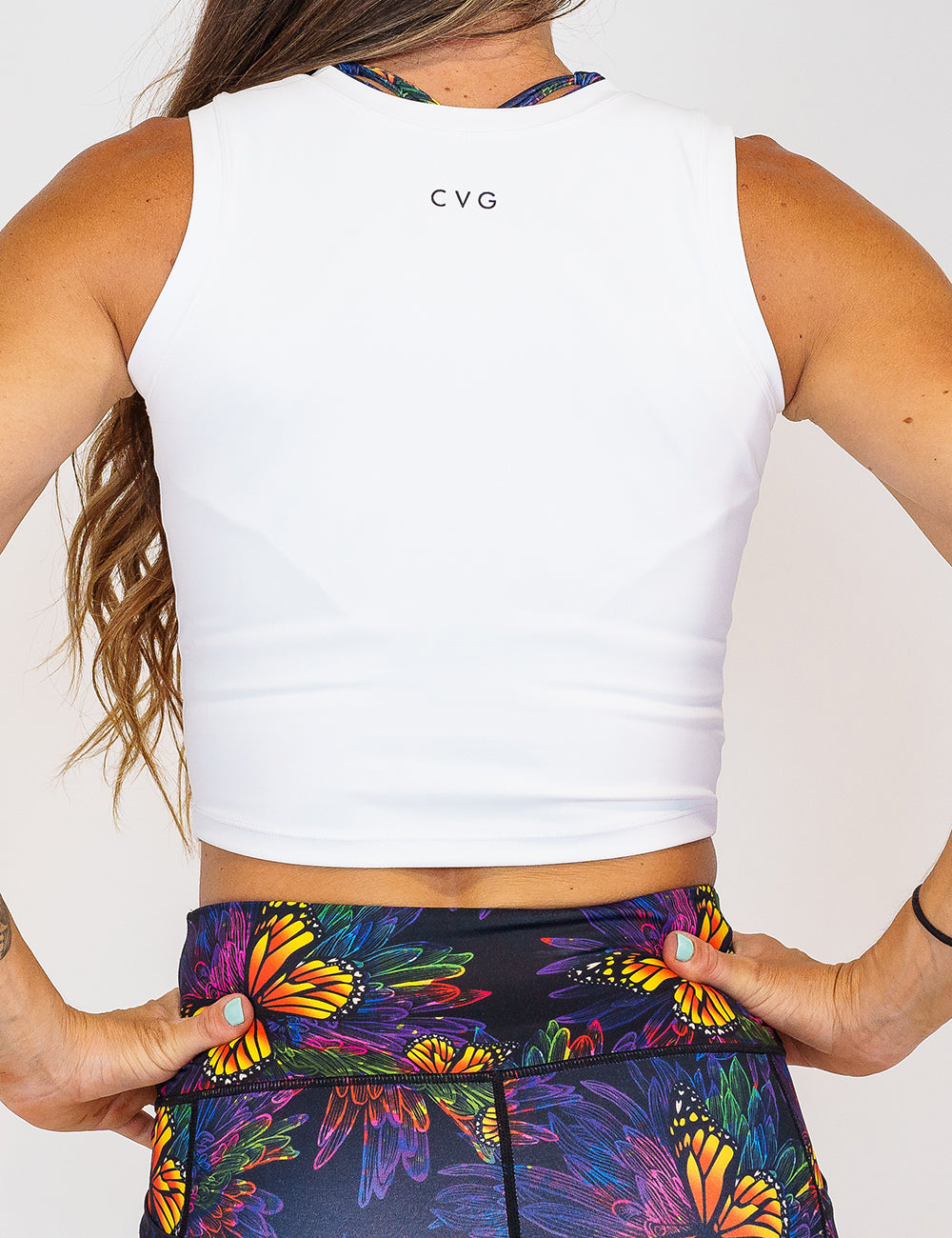 Close up photo of the back of a model wearing a white fitted crop top