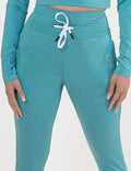 Turquoise joggers against a white background
