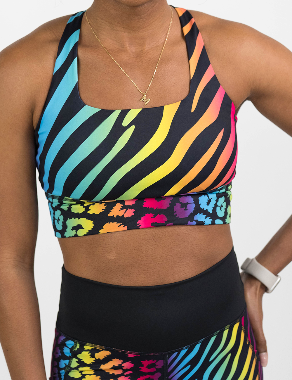 front of the zebra and leopard rainbow print longline bra against a white background