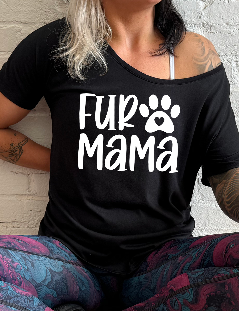 black slouchy tee with the words "fur mama" on it and a pawprint graphic with a little heart at the center of it coming soon