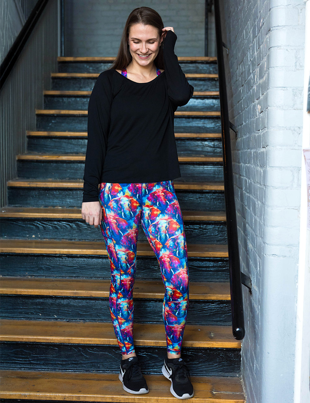 model wearing the colorful elephants leggings in a stairwell