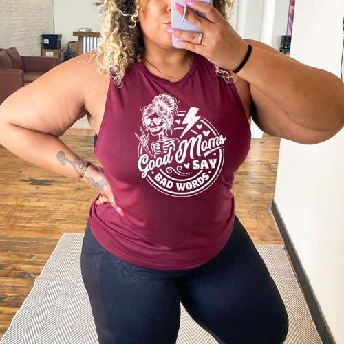 model wearing a maroon muscle tank with the saying "good moms say bad words" and a female skeleton rock symbol hand and lightning bolt