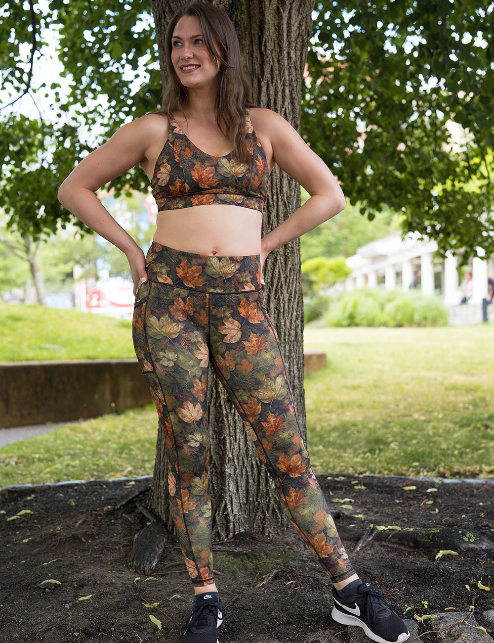 model wearing the forest floor covered in leaves full length leggings and bra