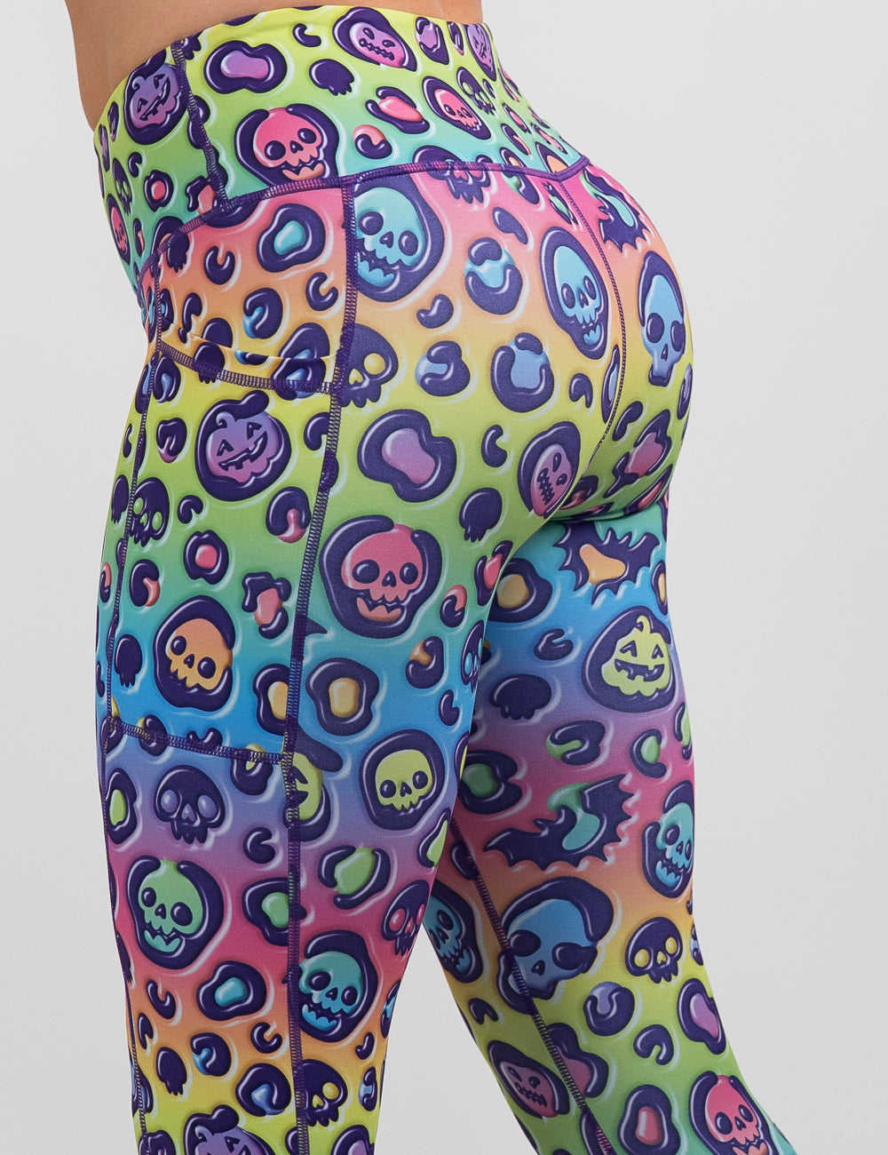 side view of the rainbow leopard print pumpkins and skulls leggings against a white background