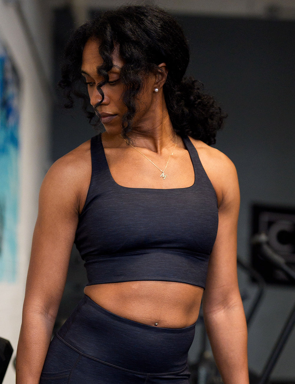 model wearing the black heather pattern longline bra posing in the gym