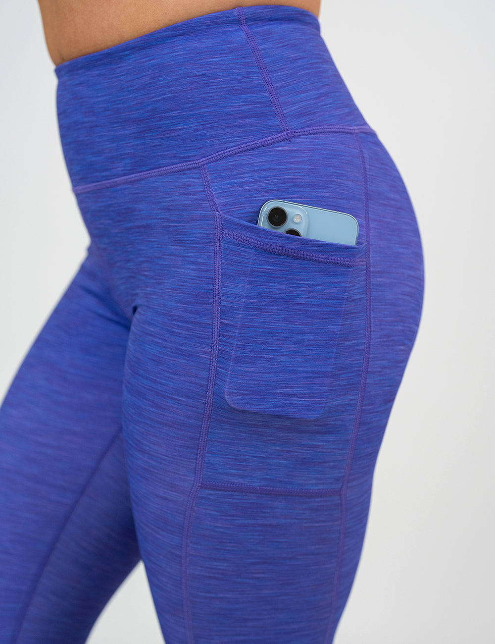 close up of the purple heather pattern leggings with a phone in its pocket