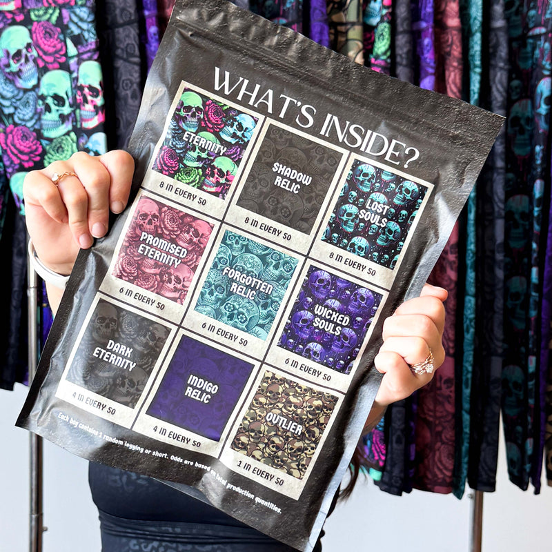 Person holding a bag with the text "what's inside" with colorful skull designs against a colorful background.