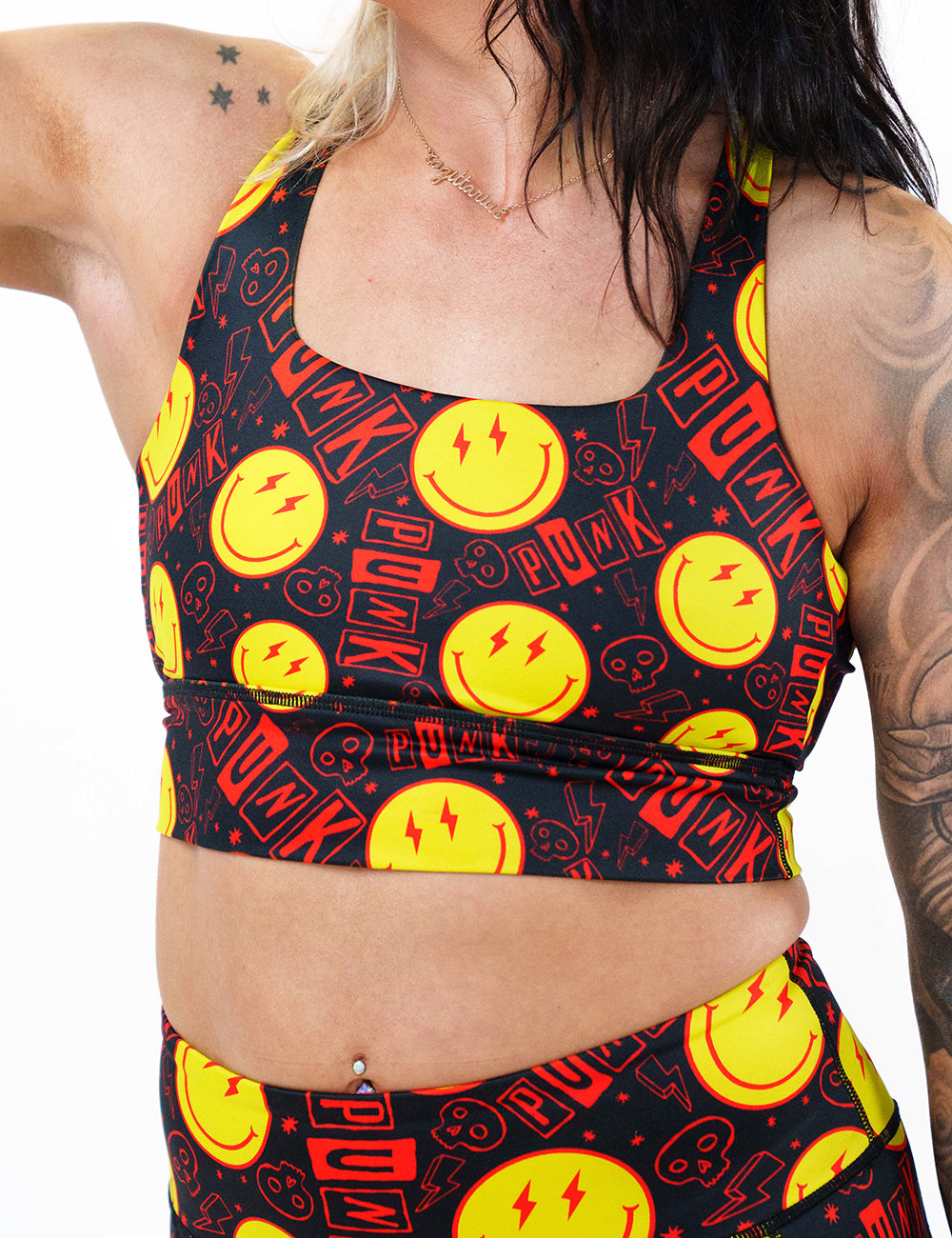 front of smiley face punk rock themed sports bra