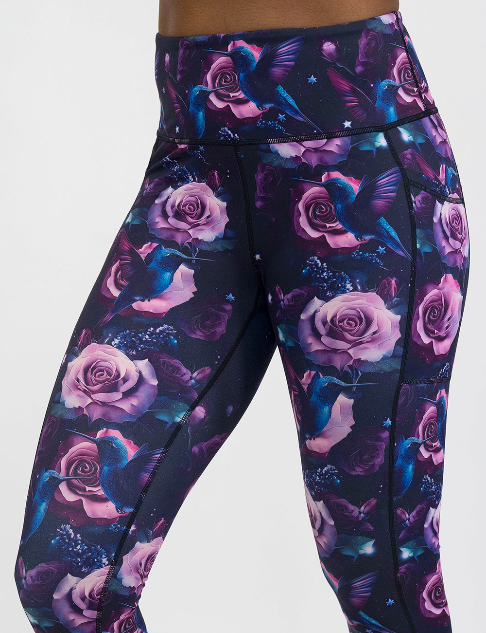 leggings with a design of a blue hummingbird and pink roses against a white background