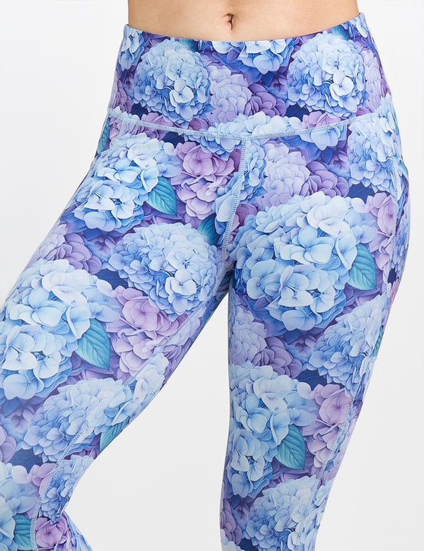 front of the pastel blue and purple hydrangea flower pattern leggings against a white background, coming July 15th