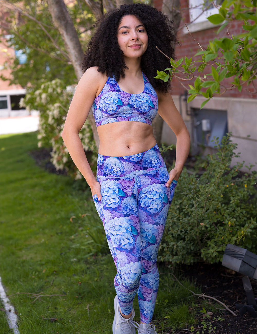 model wearing the pastel blue and purple hydrangea flower pattern full length leggings and bra 