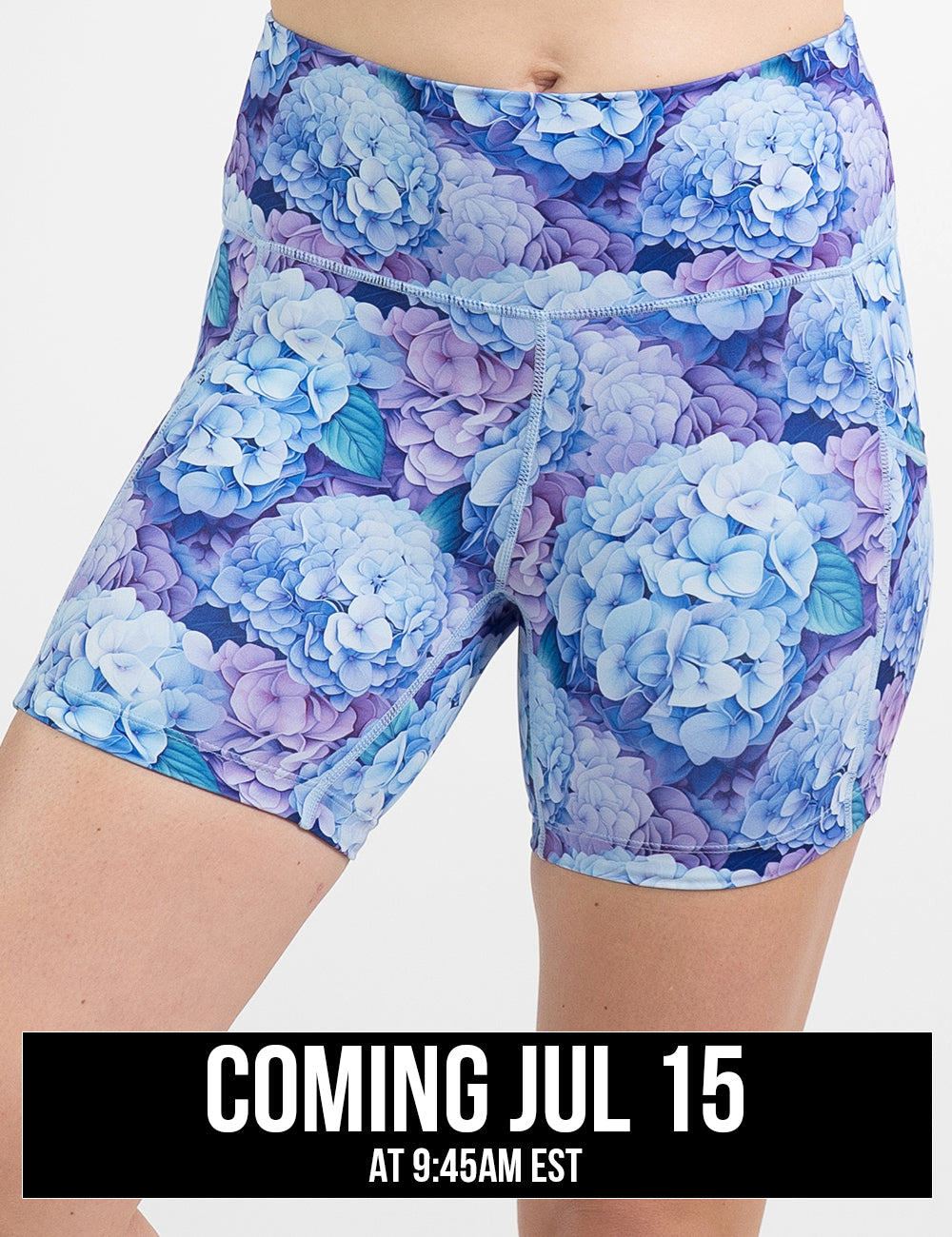 front of the 5 inch blue and purple pastel flowers shorts against a white background, coming july 15th