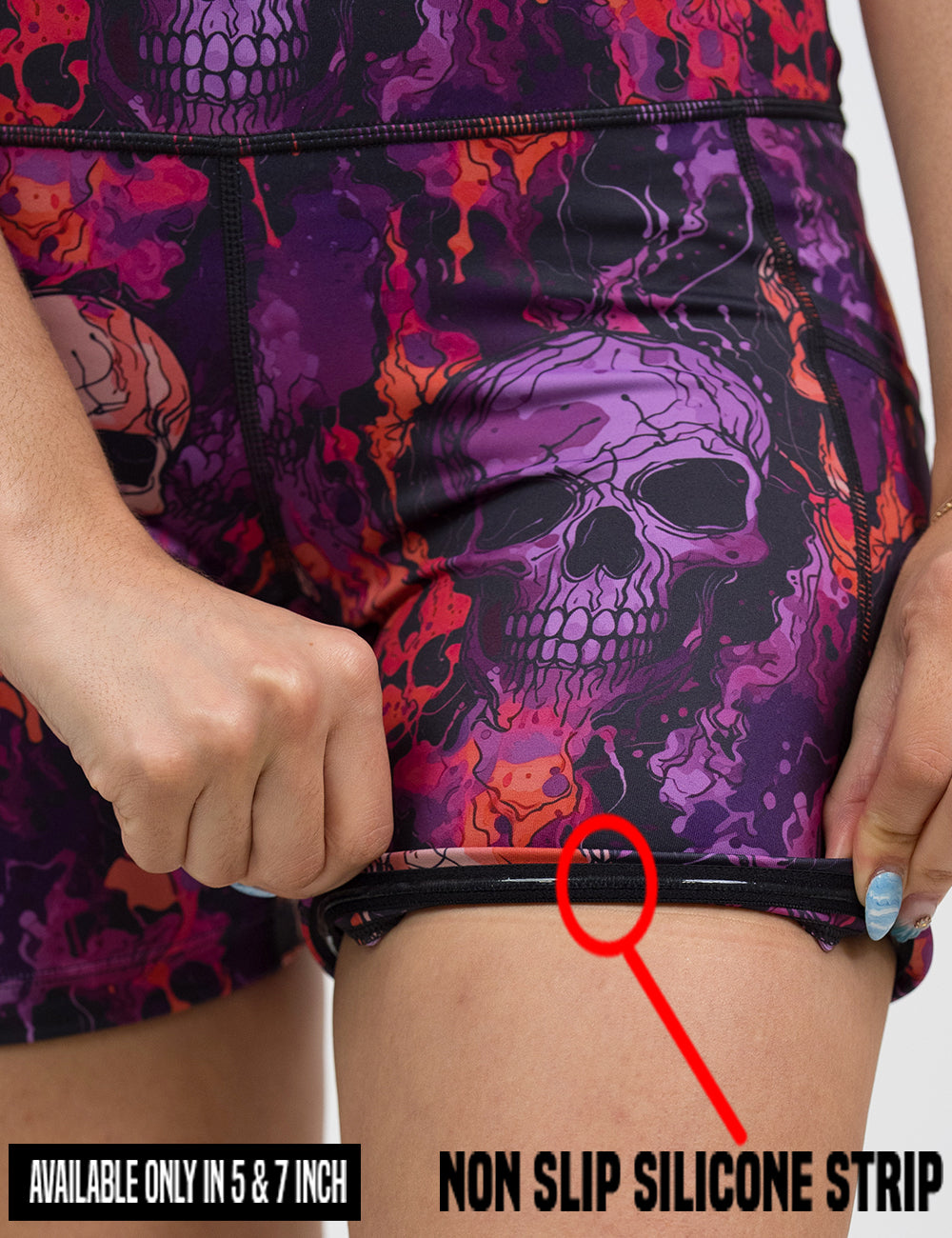 close up of the purple and orange skull patterned shorts being rolled up to show the non slip silicone strip found in only the 5 and 7 inch shorts