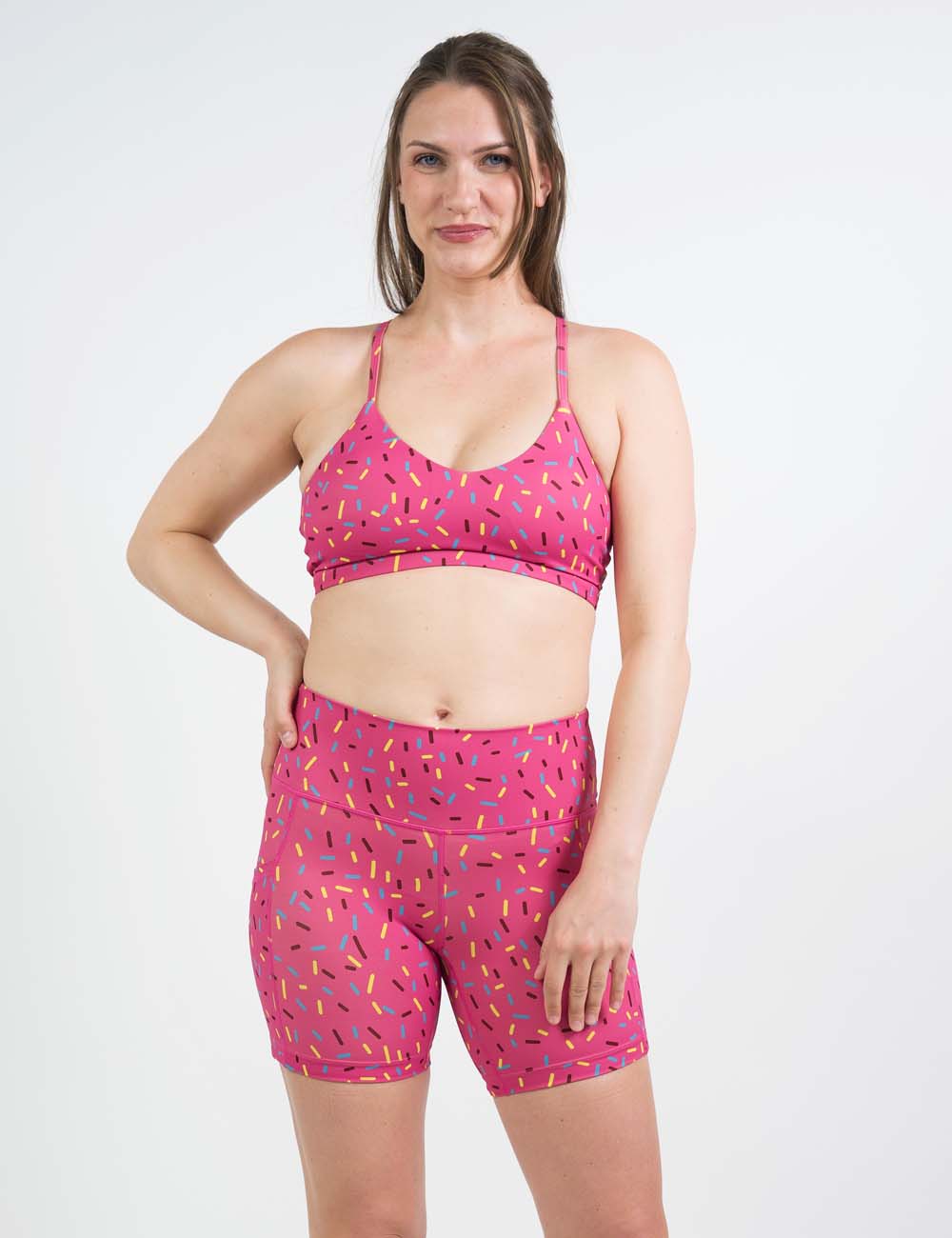 Model wearing pink sprinkle shorts and a matching sports bra