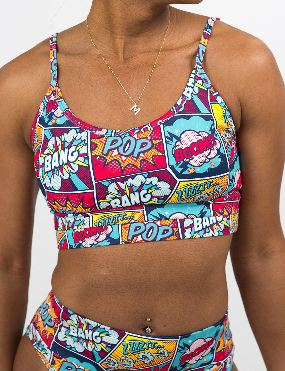 front of the comic book panel inspired patterned swimsuit top against a white background