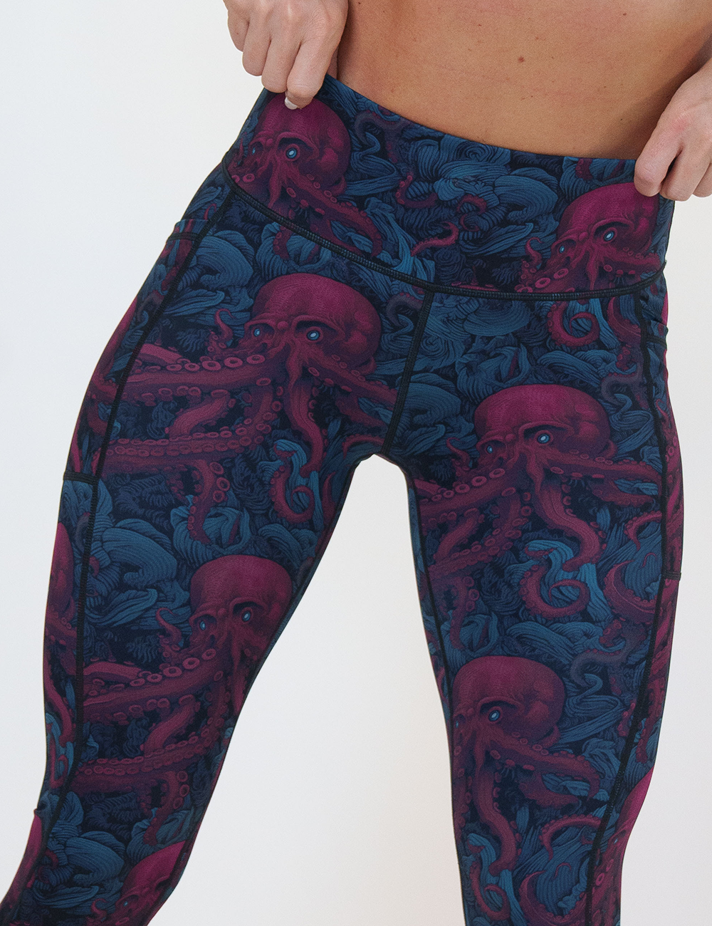close up of the maroon octopus with glowing blue eyes leggings against a white background