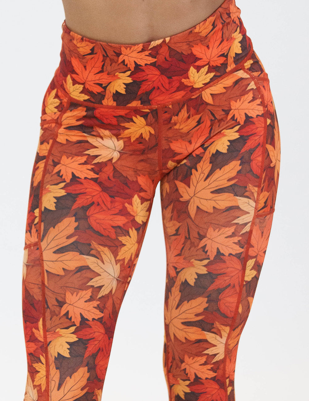 close up of the orange leaves leggings against a white background