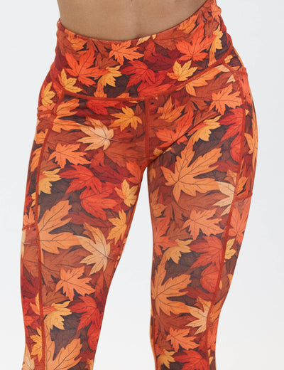 close up of the orange leaves leggings against a white background