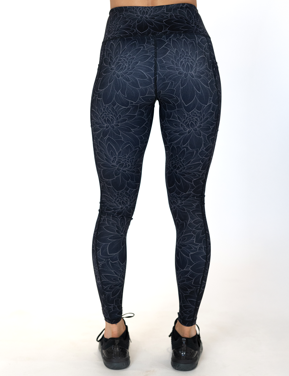 back of the full length black lotus flower leggings against a white background