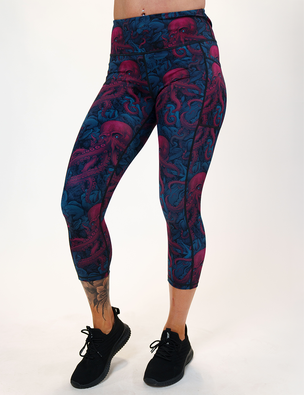 model wearing the maroon octopus with glowing blue eyes capri leggings facing the front against a white background