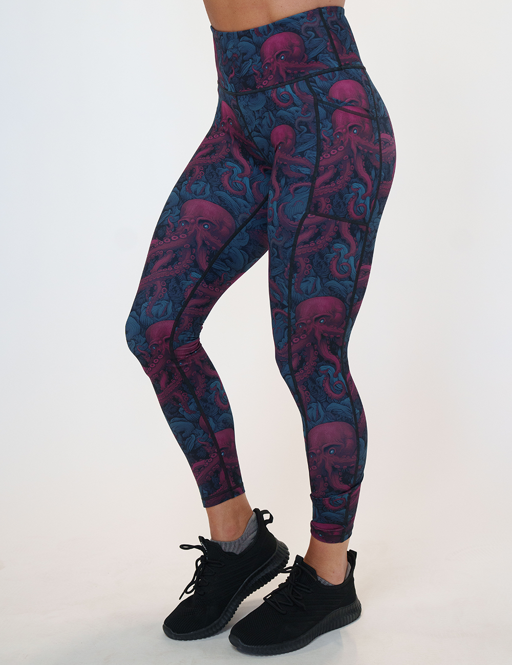 model wearing the maroon octopus with blue glowing eyes full length leggings facing the front against a white background