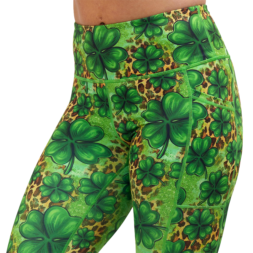 close up of the clover pattern against a cheetah print and green background leggings against a white background
