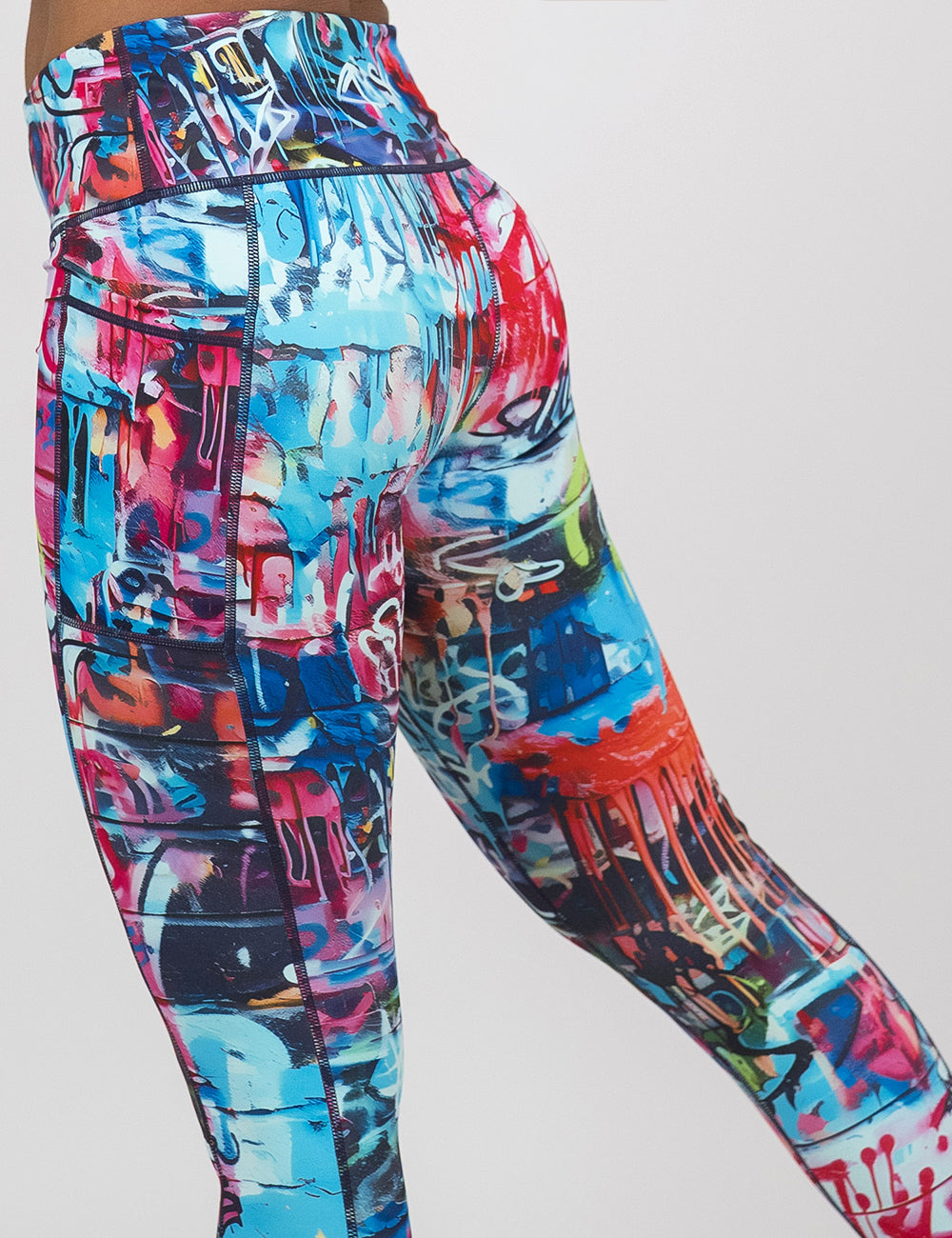 back of the multi colored graffiti covered leggings against a white background
