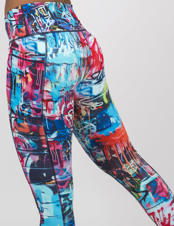 back of the multi colored graffiti covered leggings against a white background