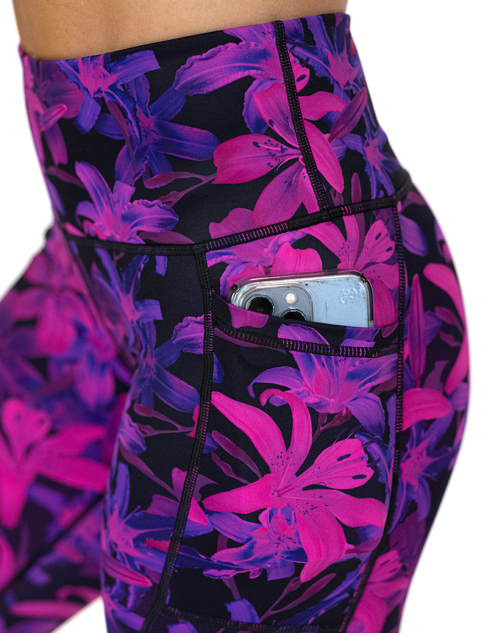 close up of the vibrant purple leggings pocket holding a phone against a white background