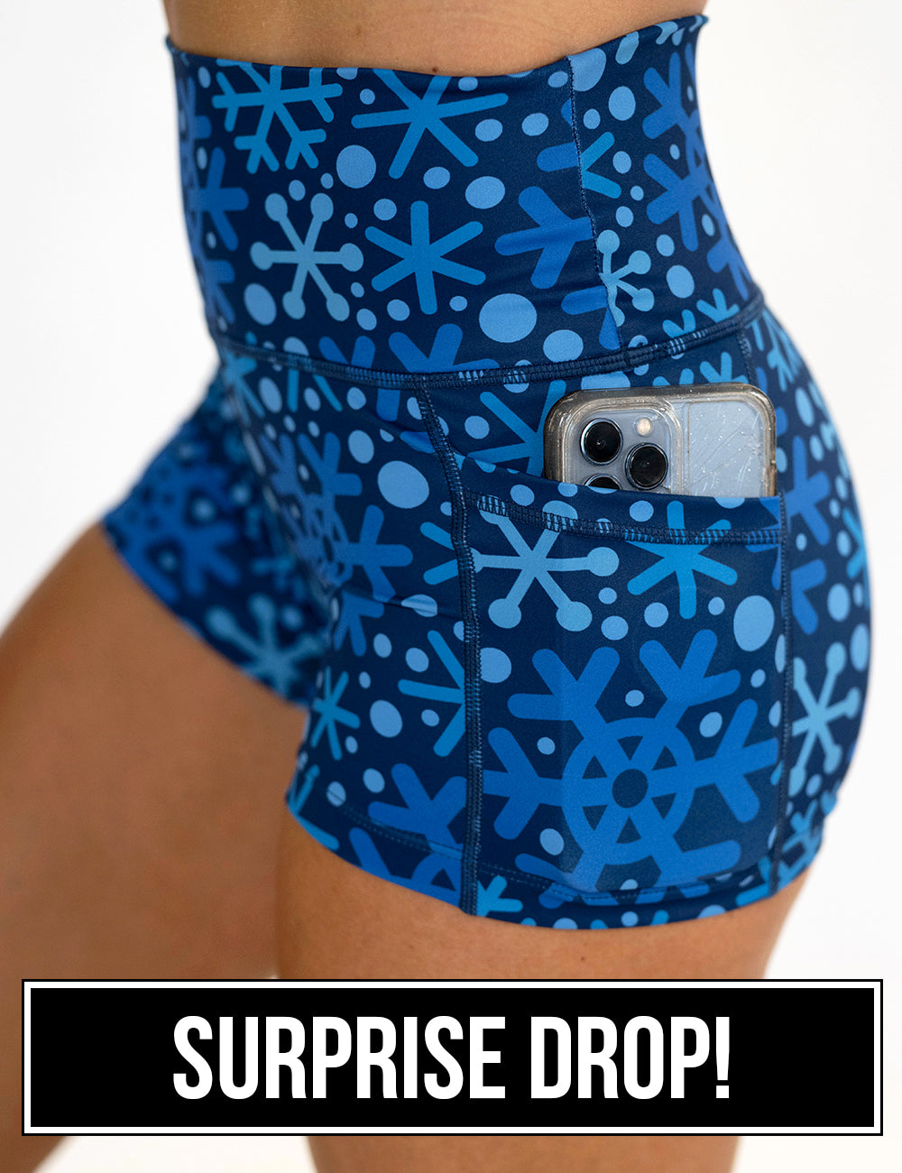 close up of the blue snowflakes on a dark blue background 2.5 inch shorts with a phone in its pocket, surprise drop