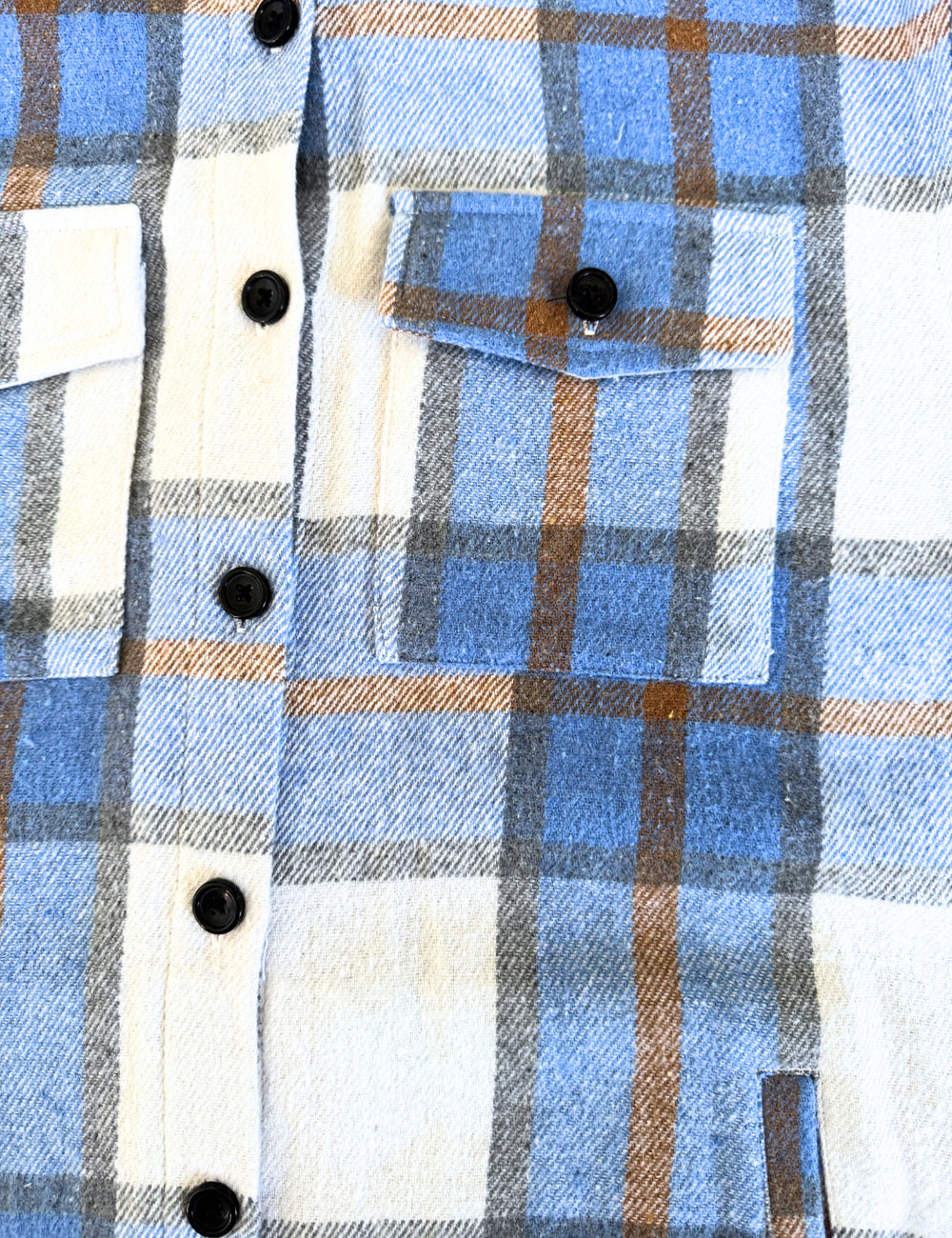 close up of the light blue, gold, black, and white plaid jacket
