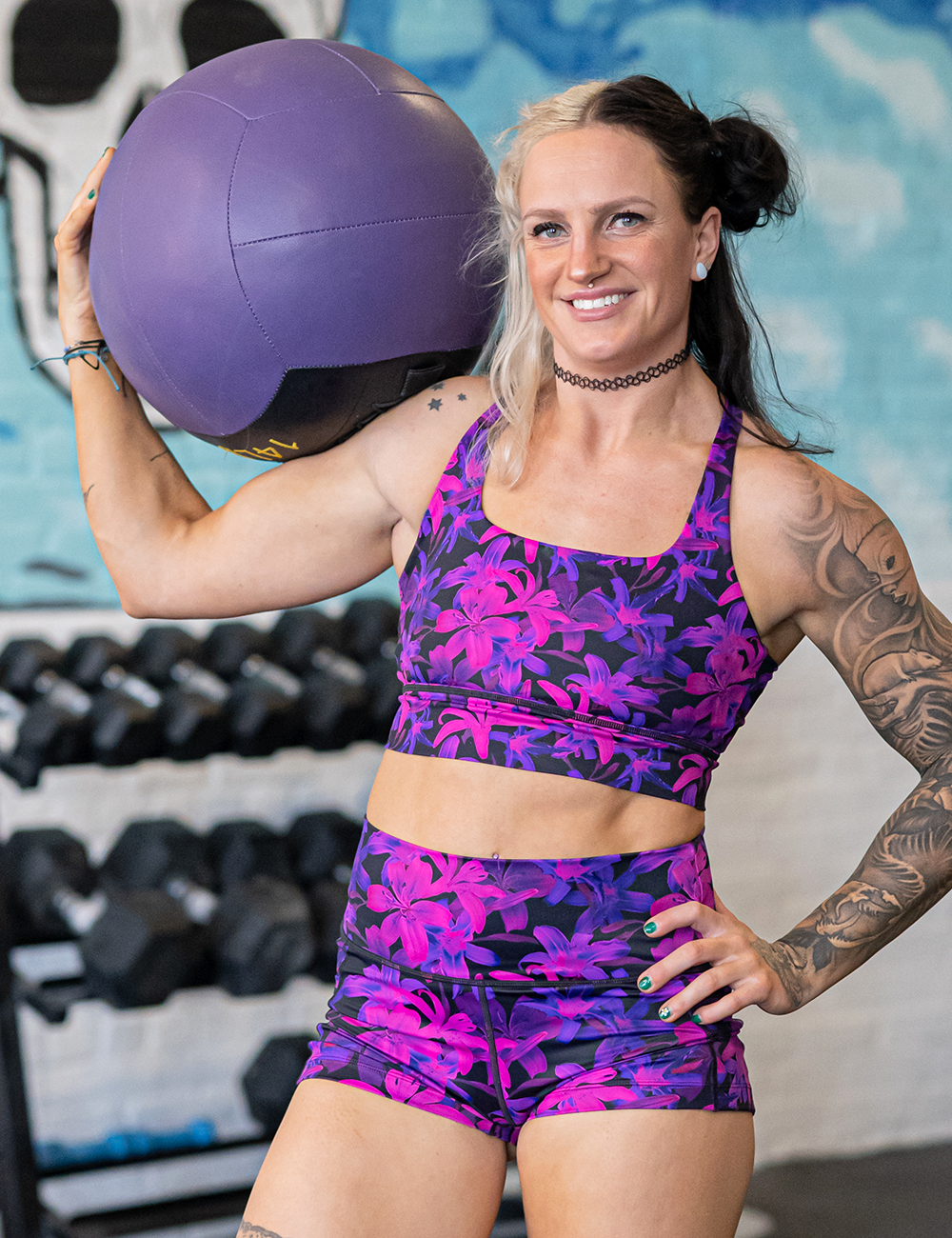 model wearing the vibrant purple flowers bra in the gym
