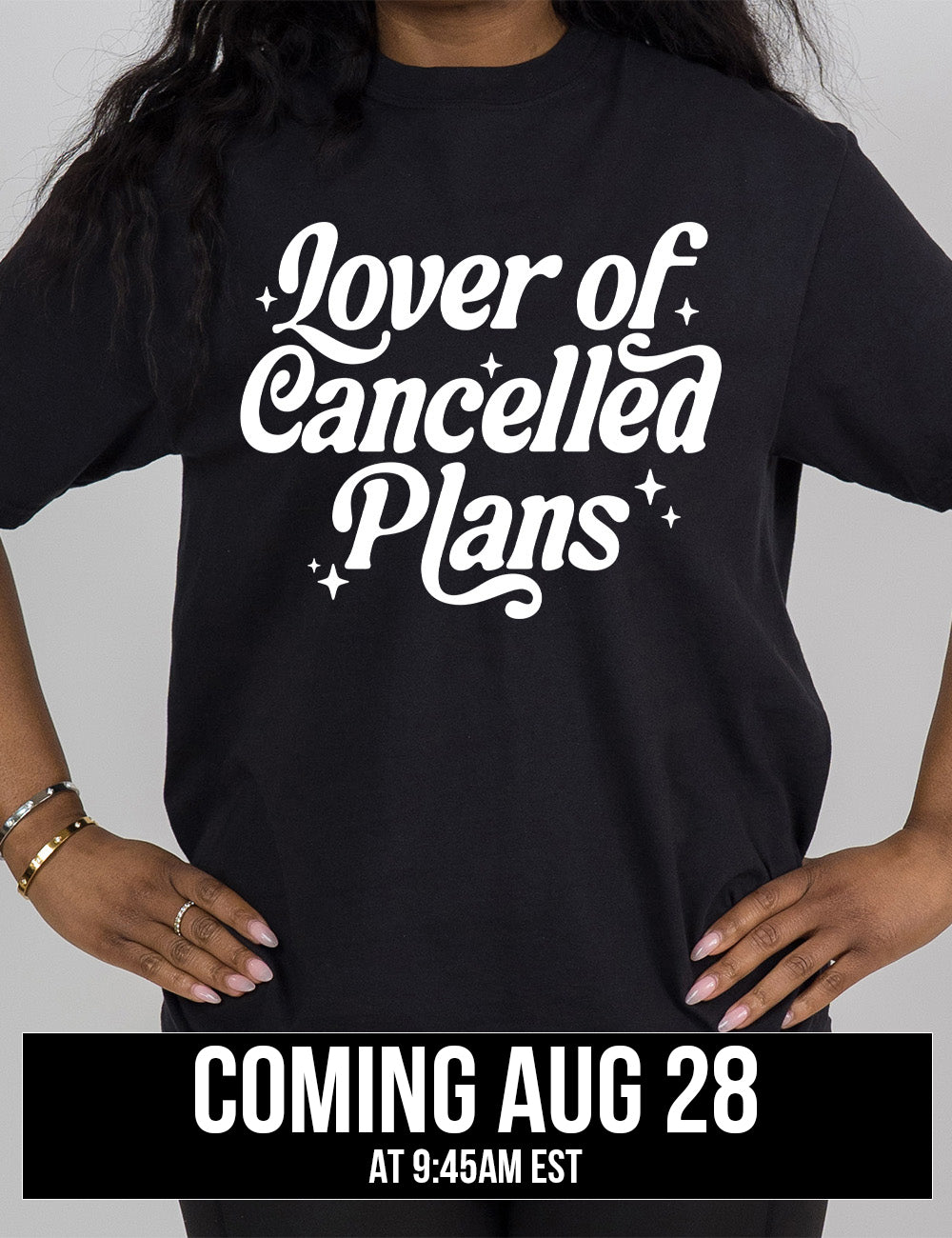 black modern tee with the words on it saying "lover of cancelled plans" with a few stars around the words, coming august 28th