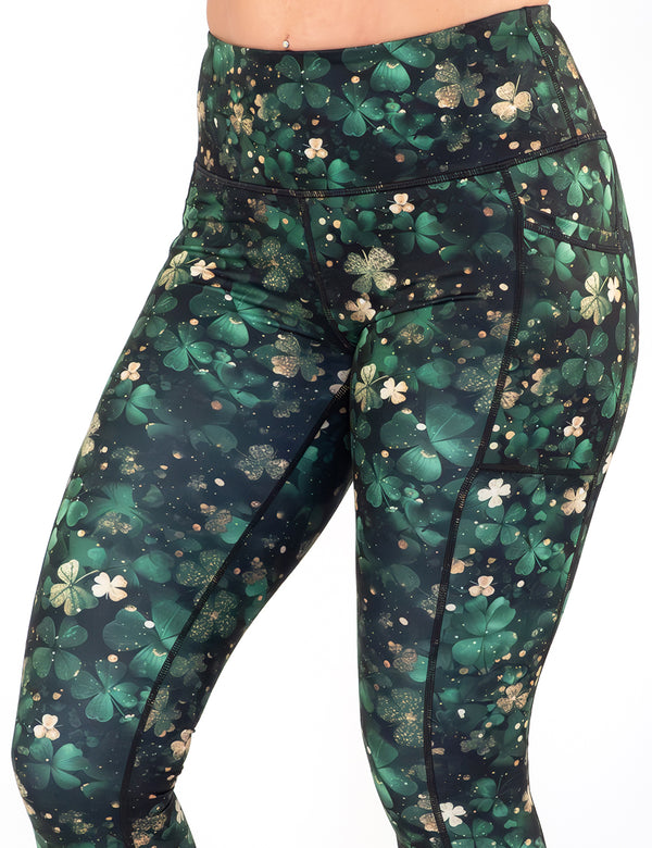 close up of the green and gold shamrock patterned leggings against a white background