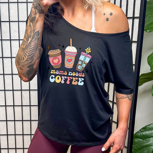 model wearing a black slouchy tee with the saying "mama needs coffee" on it