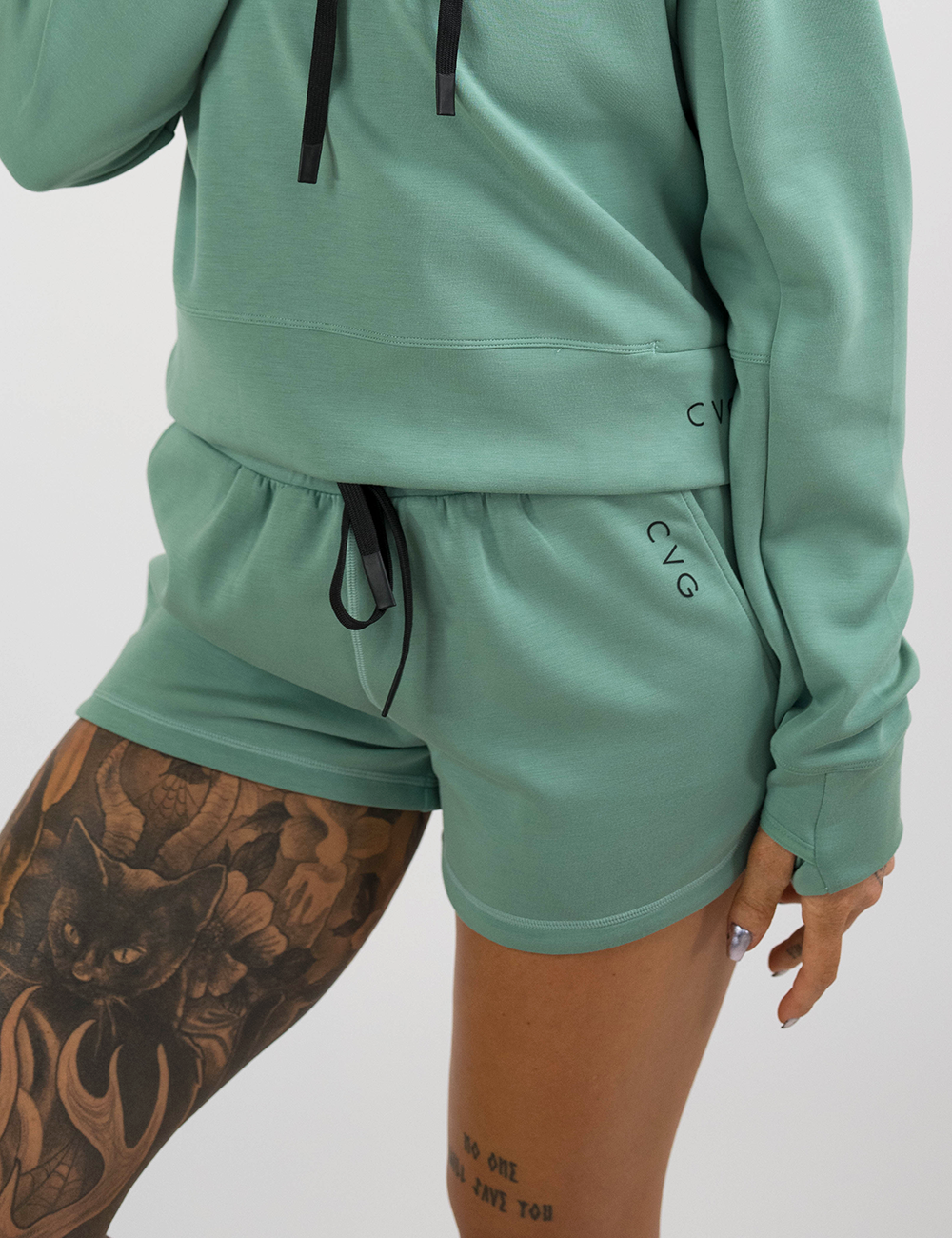 model wearing the light green luxe shorts and hoodie against a white background